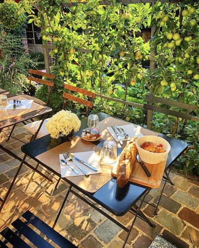 une table avec un panier de nourriture en haut dans l'établissement La Cour Sainte Catherine demeure de charme, à Honfleur