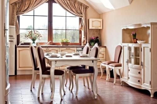 a dining room with a table and chairs and a window at Pensjonat Enklawa in Trzebnica