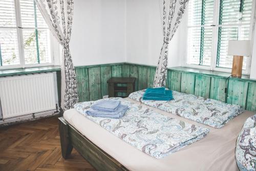 dwa łóżka w pokoju z oknami w obiekcie Gemütliches Wohnen in der alten Schule w mieście Weitra