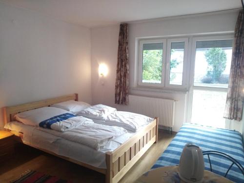 Schlafzimmer mit einem Bett und einem Fenster in der Unterkunft Pokoje Gościnne Irena in Bukowina Tatrzańska