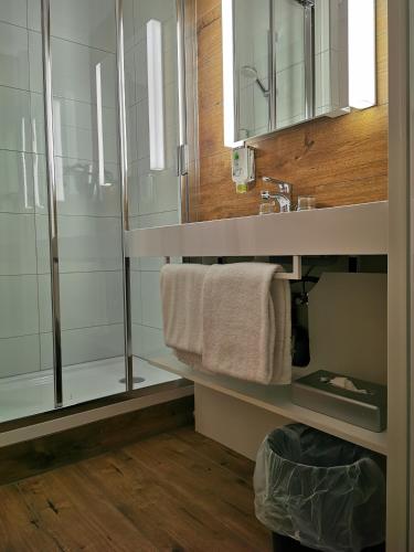 a bathroom with a sink and a mirror at Plaza Inn Berlin Süd Ludwigsfelde in Ludwigsfelde