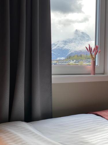a bedroom window with a view of a snow covered mountain at Frichs Ekspress Åndalsnes in Åndalsnes