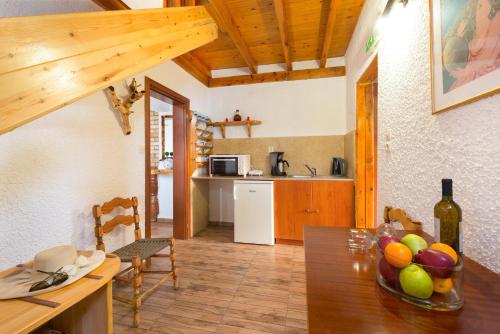 a kitchen and dining room with a table with a bowl of fruit at Elefteria Apts & Suites in Kolimbia