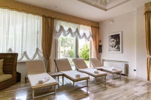 a living room with couches and tables in front of a window at Grand Hotel Gallia in Milano Marittima