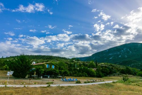 a house on a hill with mountains in the background at Gîte de Vénascle in Moustiers-Sainte-Marie