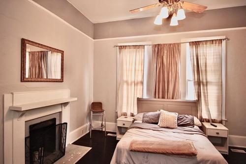 a bedroom with a bed and a fireplace and a ceiling fan at Classic/Modern Downtown Home in Valdosta