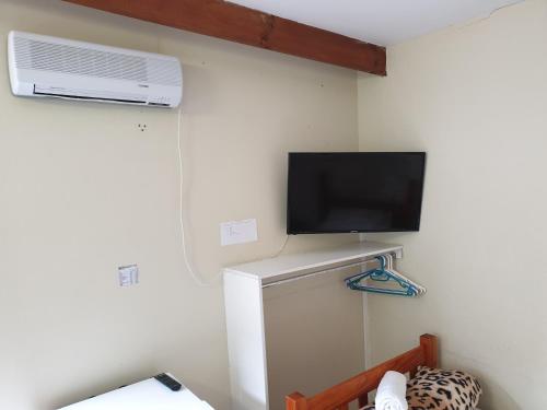 a room with a refrigerator and a tv and a fan at Amakaya Backpackers Travellers Accommodation in Plettenberg Bay