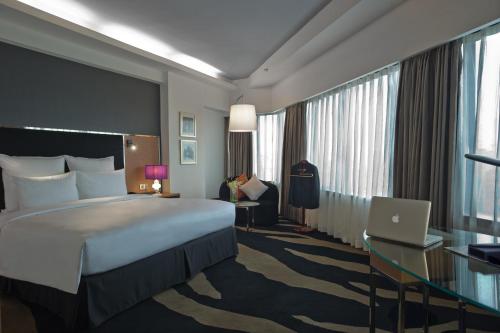 a hotel room with a bed and a desk and a laptop at Wyndham Grand Bangsar Kuala Lumpur in Kuala Lumpur