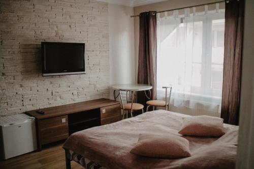 a bedroom with a bed and a tv on a brick wall at MARMAT Łeba in Łeba