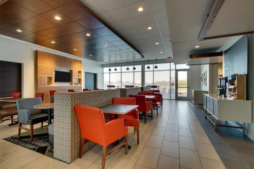 a restaurant with red chairs and tables in a cafeteria at Holiday Inn Express & Suites Findlay North by IHG in Findlay