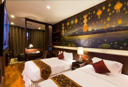 a hotel room with two beds and a painting on the wall at Sireeampan Boutique Resort and Spa in Chiang Mai