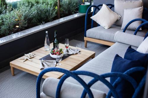 a patio with a table with two chairs and wine bottles at Boutique Hotel Vissi d'Arte in Budva