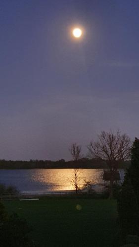 a full moon rising over a lake at night at Haus Seeblick in Timmendorfer Strand
