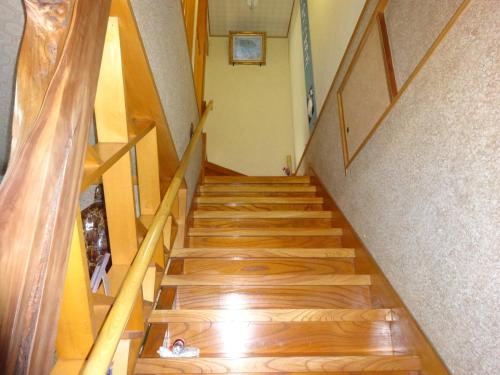 a staircase in a house with wooden floors at Ishibu-so in Matsuzaki