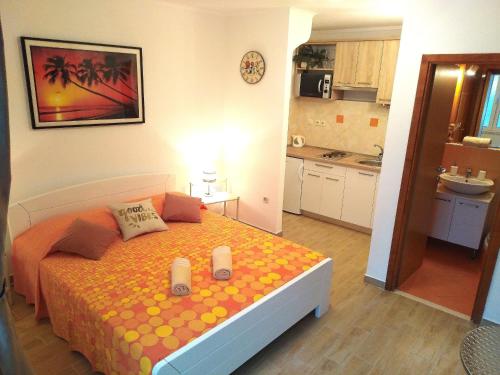 a bedroom with a bed with two candles on it at Apartments Green & Orange in Hvar