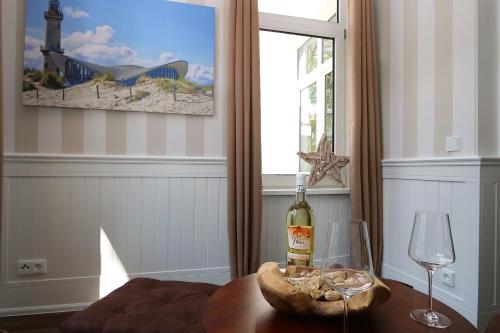 a bottle of wine on a table next to a window at Villa Ostseenordstern in Warnemünde