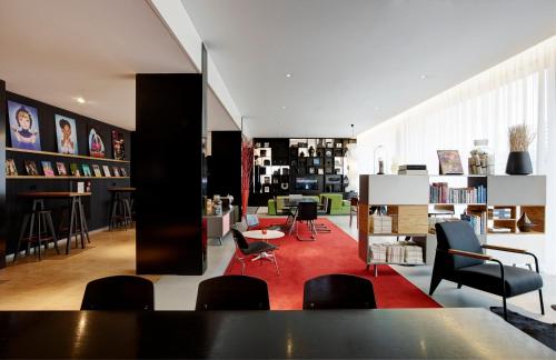 a living room filled with furniture and tables at citizenM Schiphol Airport in Schiphol