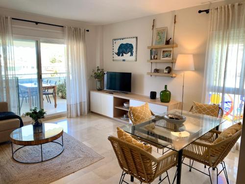 uma sala de estar com uma mesa de vidro e cadeiras em Las Petunias del Mar - EaW Homes em Marbella