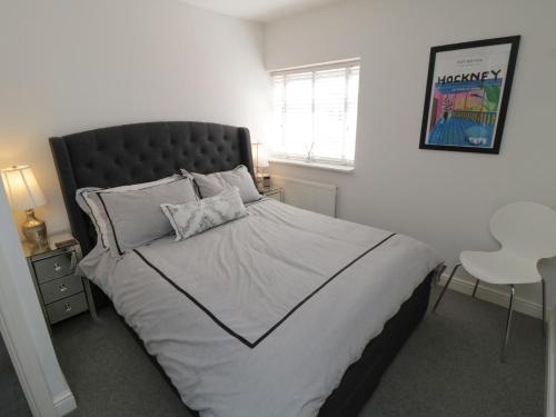 a bedroom with a large bed with a black headboard at Flat 3, Peacehaven in Whitby