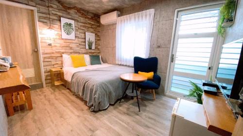 Un dormitorio con una cama y una mesa y una ventana. en Funky Song, en Tainan