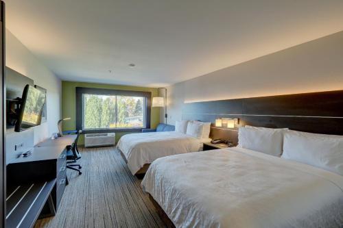 オーバーンにあるHoliday Inn Express & Suites - Auburn Downtown, an IHG Hotelのベッド2台と窓が備わるホテルルームです。