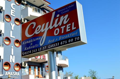 una señal para una tienda de aceite de California al lado de un edificio en Amasra Ceylin Otel, en Amasra