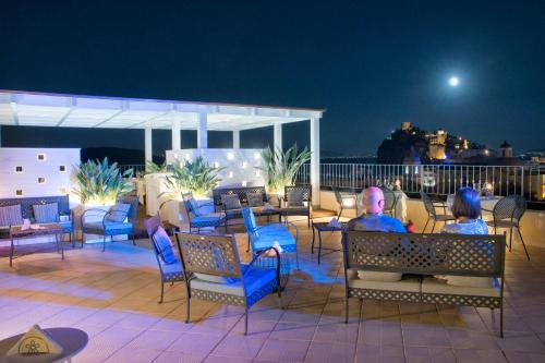 a man and woman sitting on a patio at night at Hotel Villa Durrueli Resort & Spa in Ischia