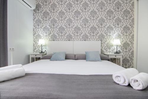 1 dormitorio con 1 cama blanca grande y toallas. en Kasa Katia Eco Guest House en Valencia