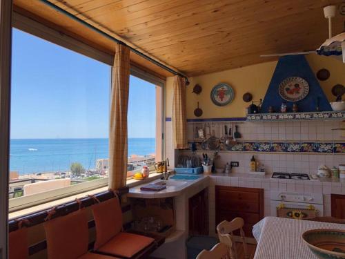 una cucina con vista sull'oceano da una finestra di Casa vacanze Sciacca a Sciacca