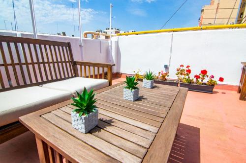 einen Holztisch auf einem Balkon mit Sofa und Pflanzen in der Unterkunft Kasa Katia Eco Guest House in Valencia