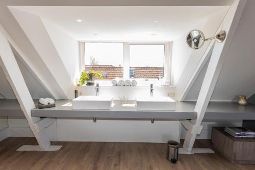 a bathroom with two sinks and a window at Gravenstraat in Den Burg