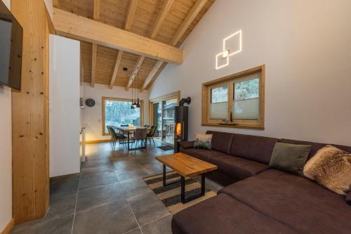 ein Wohnzimmer mit einem Sofa und einem Tisch in der Unterkunft Chalet Glemmtal - Haus Bergblick in Viehhofen