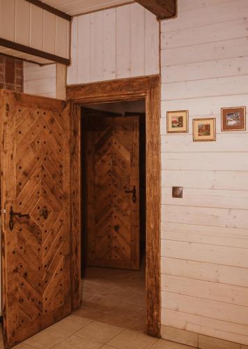 a wooden door in a room with a wall at Przystanek Ropienka Leśniczówka in Ropienka