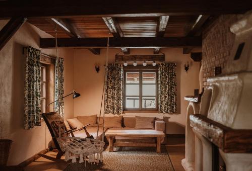 a living room with a couch and a swing at Przystanek Ropienka Leśniczówka in Ropienka