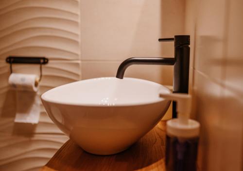 a bathroom with a bowl sink and a faucet at Przystanek Ropienka Leśniczówka in Ropienka