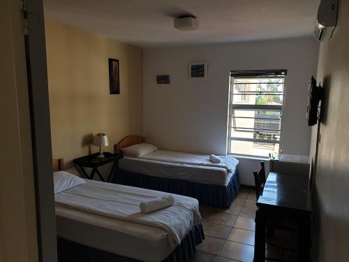 a room with two beds and a window at Amakaya Backpackers Travellers Accommodation in Plettenberg Bay