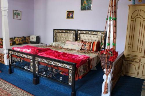 a bedroom with a bed with a red blanket at Fort View Guest House in Baltit