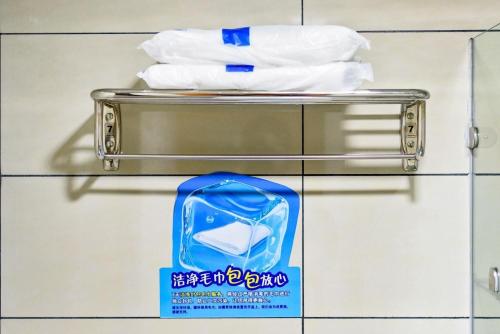 a towel rack in a bathroom with white towels at 7Days Inn Nanan Shuitou southeast Fortune Plaza in Quanzhou