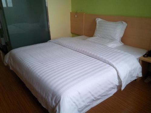 1 cama blanca grande en una habitación en 7Days Inn Ji`Nan Railway Station JingYi Road 4th en Jinan