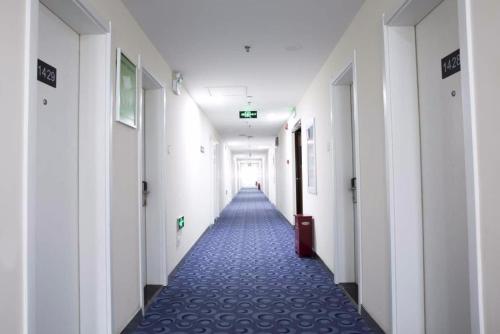 a hallway of an office building with a long corridor at 7Days Inn Qinhuangdao Railway Station in Qinhuangdao