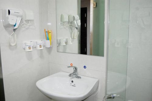a bathroom with a sink and a mirror and a shower at 7Days Inn Qinhuangdao Railway Station in Qinhuangdao