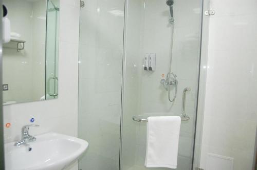 a bathroom with a shower and a sink and a shower at 7Days Inn Qinhuangdao Railway Station in Qinhuangdao