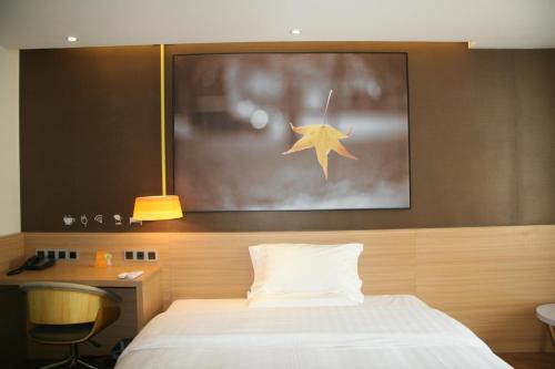 um quarto com uma cama com uma estrela na parede em 7Days Inn Datong Fengcheng Centre em Dandong