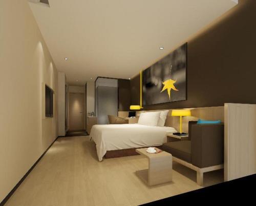 um quarto de hotel com uma cama e um sofá em 7Days Inn Datong Fengcheng Centre em Dandong