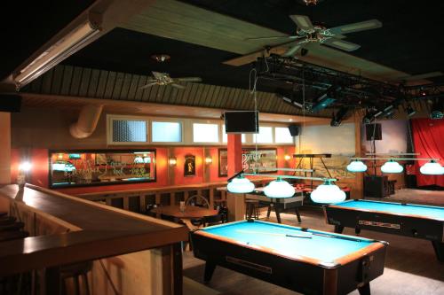 eine Bar mit zwei Billardtischen und Tischtennisbällen in der Unterkunft Erlebnisland Grizzlybär in Längenbühl 
