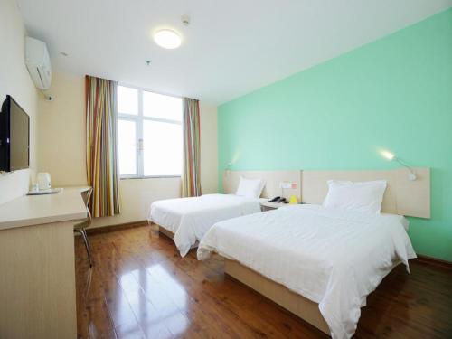 a hotel room with two beds and a television at 7Days Inn Guilin Qixing Road in Guilin