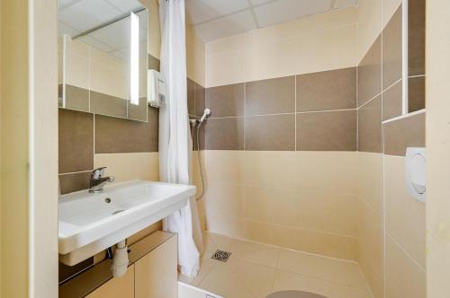 uma casa de banho com um lavatório e um chuveiro em Hotel Cantosorgue em LʼIsle-sur-la-Sorgue