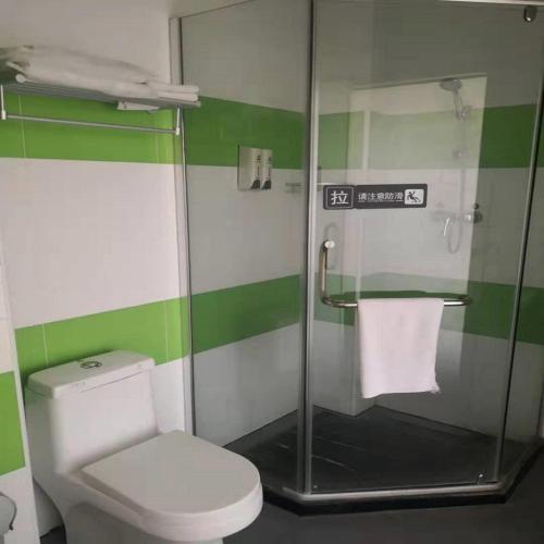 a green and white bathroom with a toilet and a shower at 7Days Inn Zhangjiakou Xuanhua Caishenmiao Street in Zhangjiakou