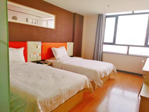 a hotel room with two beds and a window at 7Days Inn Jinchang Culture Street in Jinchang