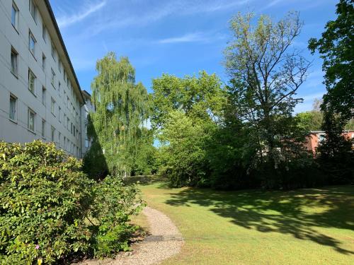 een tuin naast een gebouw met bomen bij Ferienwohnung Washingtonweg in Hannover